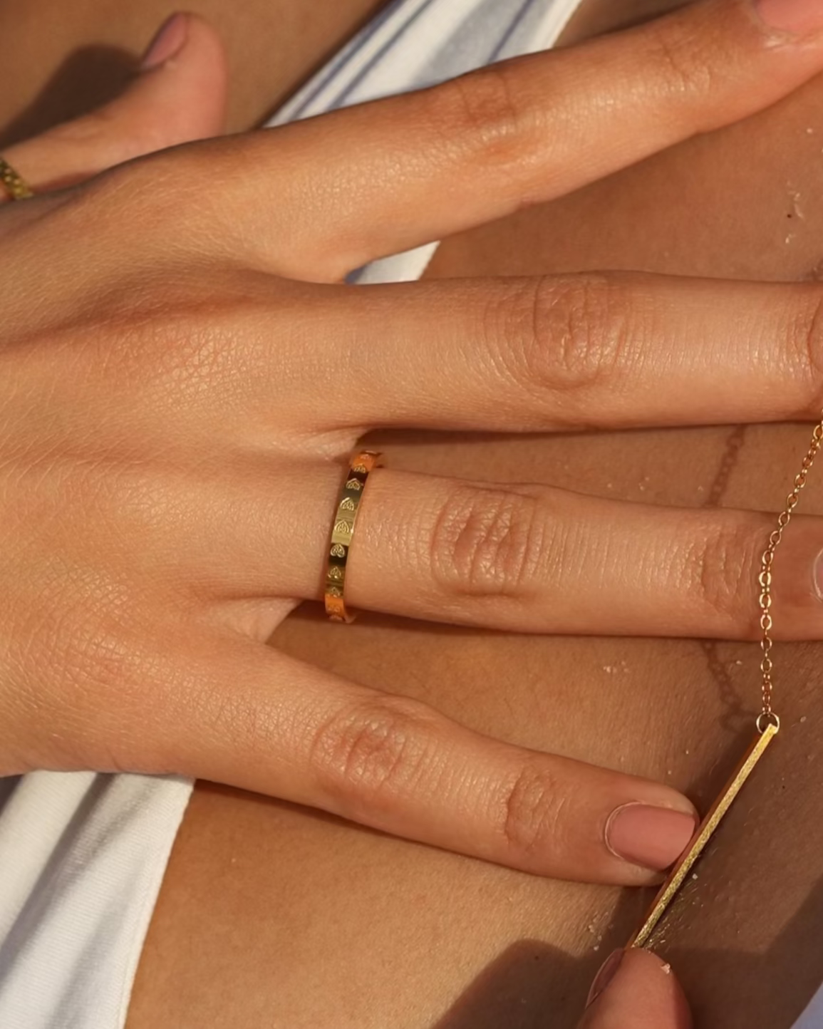 Close-up of a person wearing gold jewelry with a blurred background