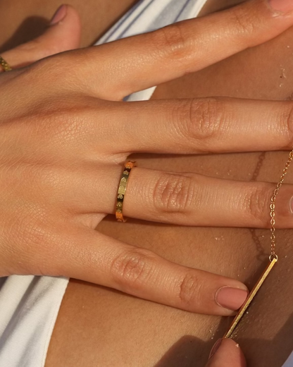 Close-up of a person wearing gold jewelry with a blurred background